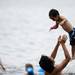 Ann Arbor resident Hiroshi Murayama throws Kanta, 3, in the air while playing in Independence Lake on Saturday, July 6. Daniel Brenner I AnnArbor.com